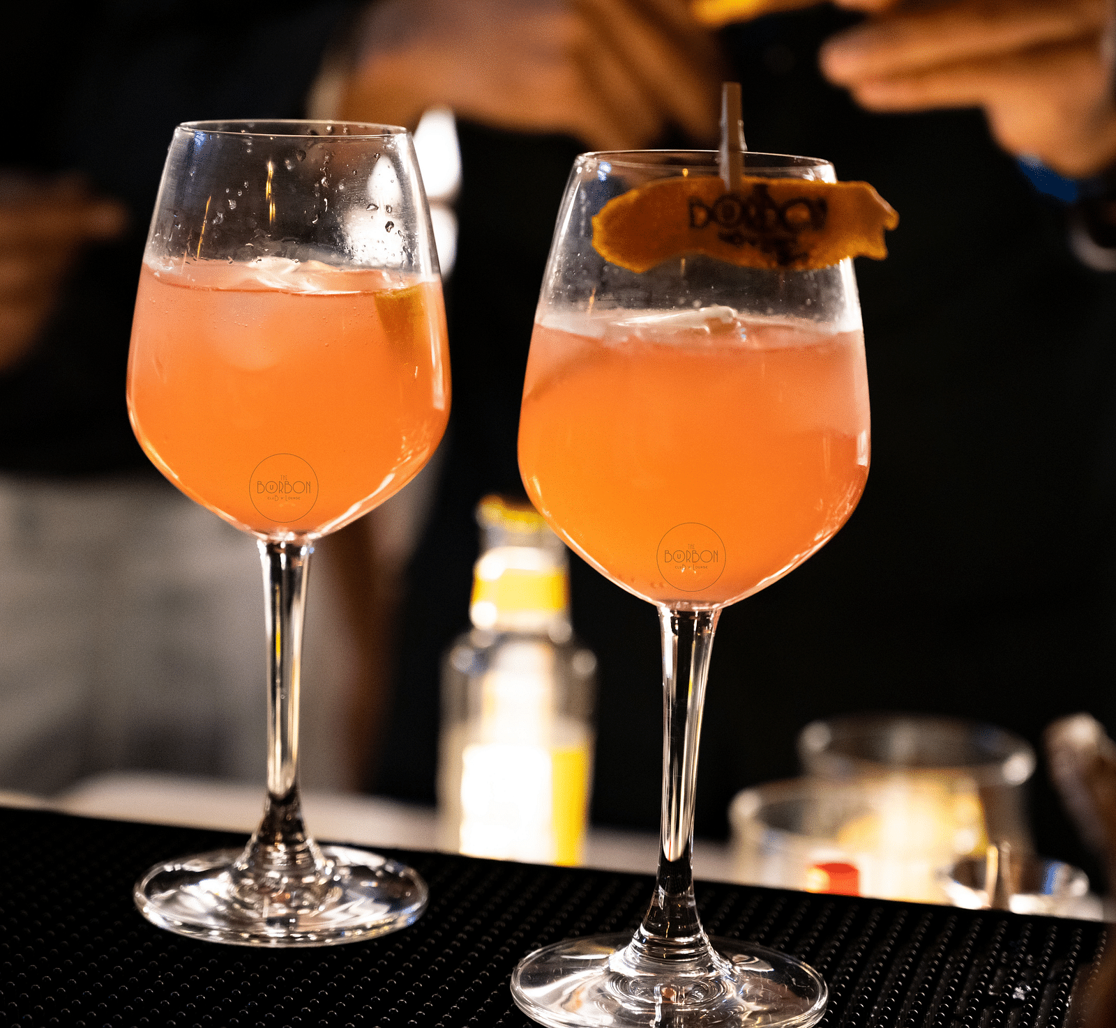image of two wine glasses with orange coloured beverage at the bourbon club and lounge - The Tattva Boutique Resort