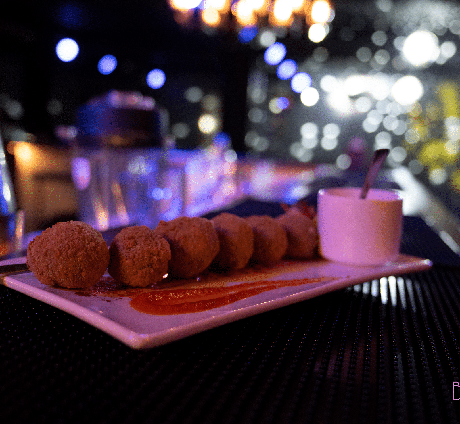 image of a plate with snacks served with a dip at the bourbon club and lounge - The Tattva Boutique Resort