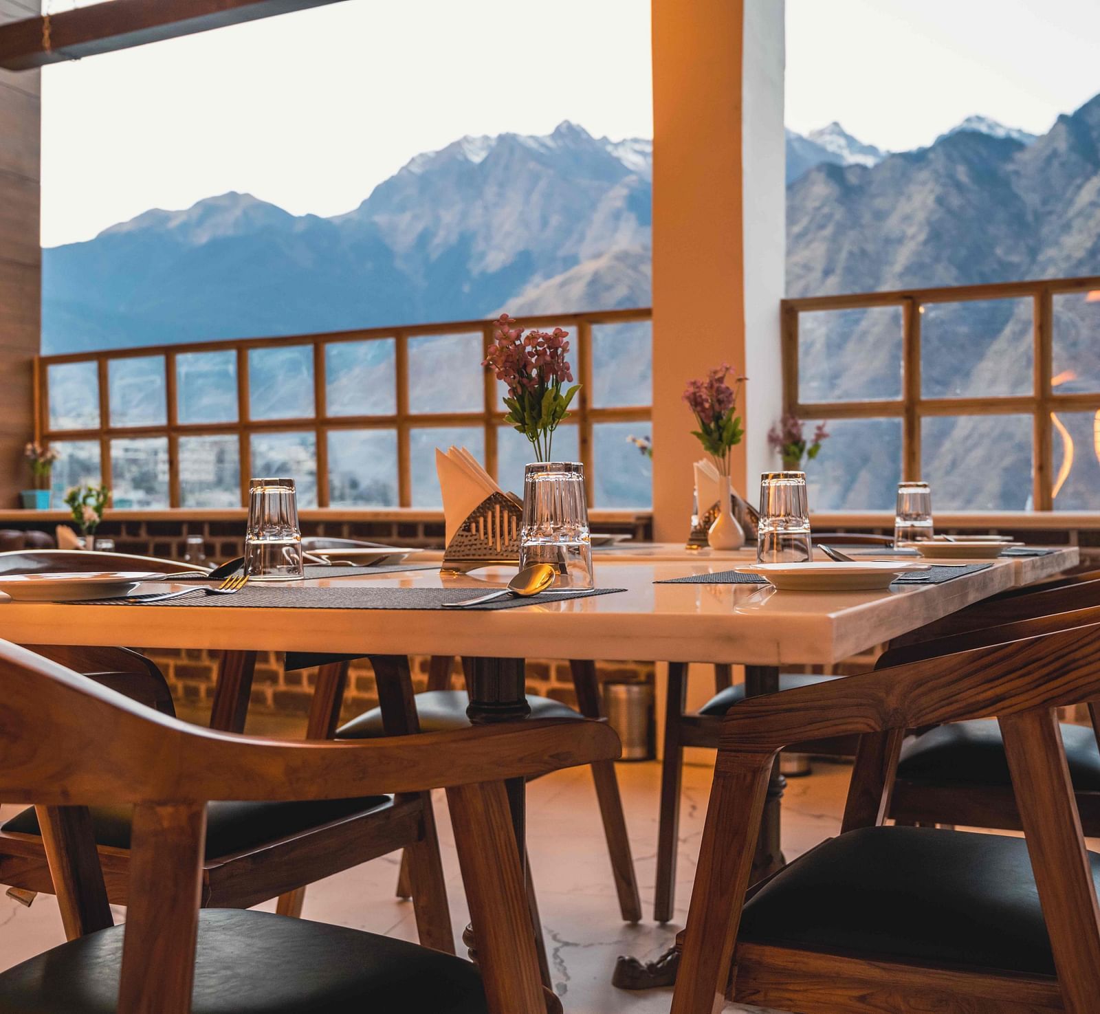 image of the indoor dining area of the alpenrose restaurant featuring a table over looking the beautiful mountain views - the tattva boutique resort