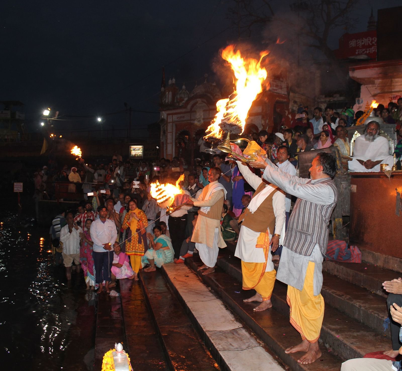 image of temple priest performing ganga aarti in the late evening on the river bank