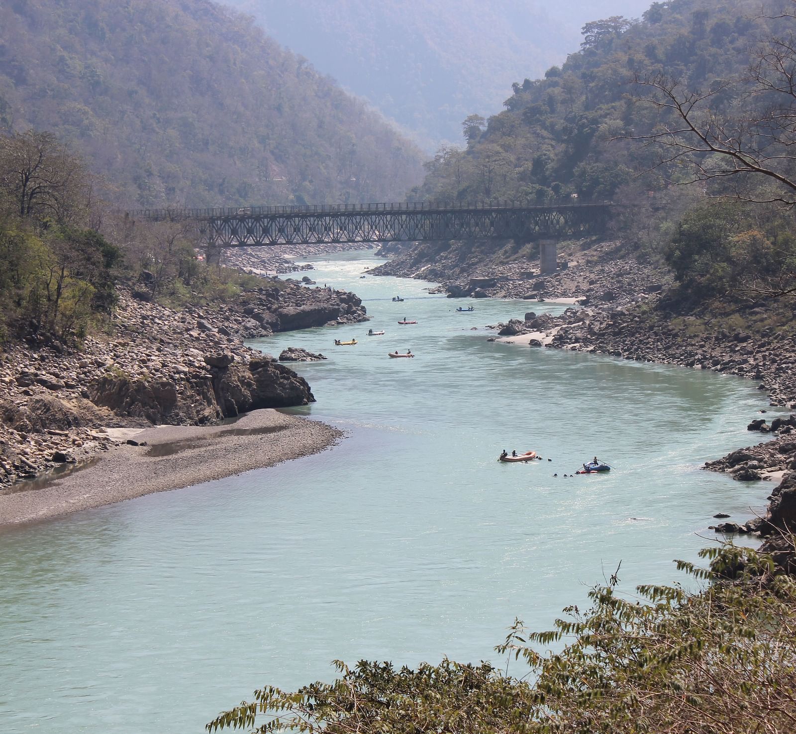 image featuring a stream of river going through mountain ranges on a foggy day