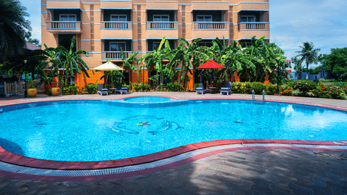 Image featuring the facade of MGM Vailankanni Residency and a large swimming pool in front of it