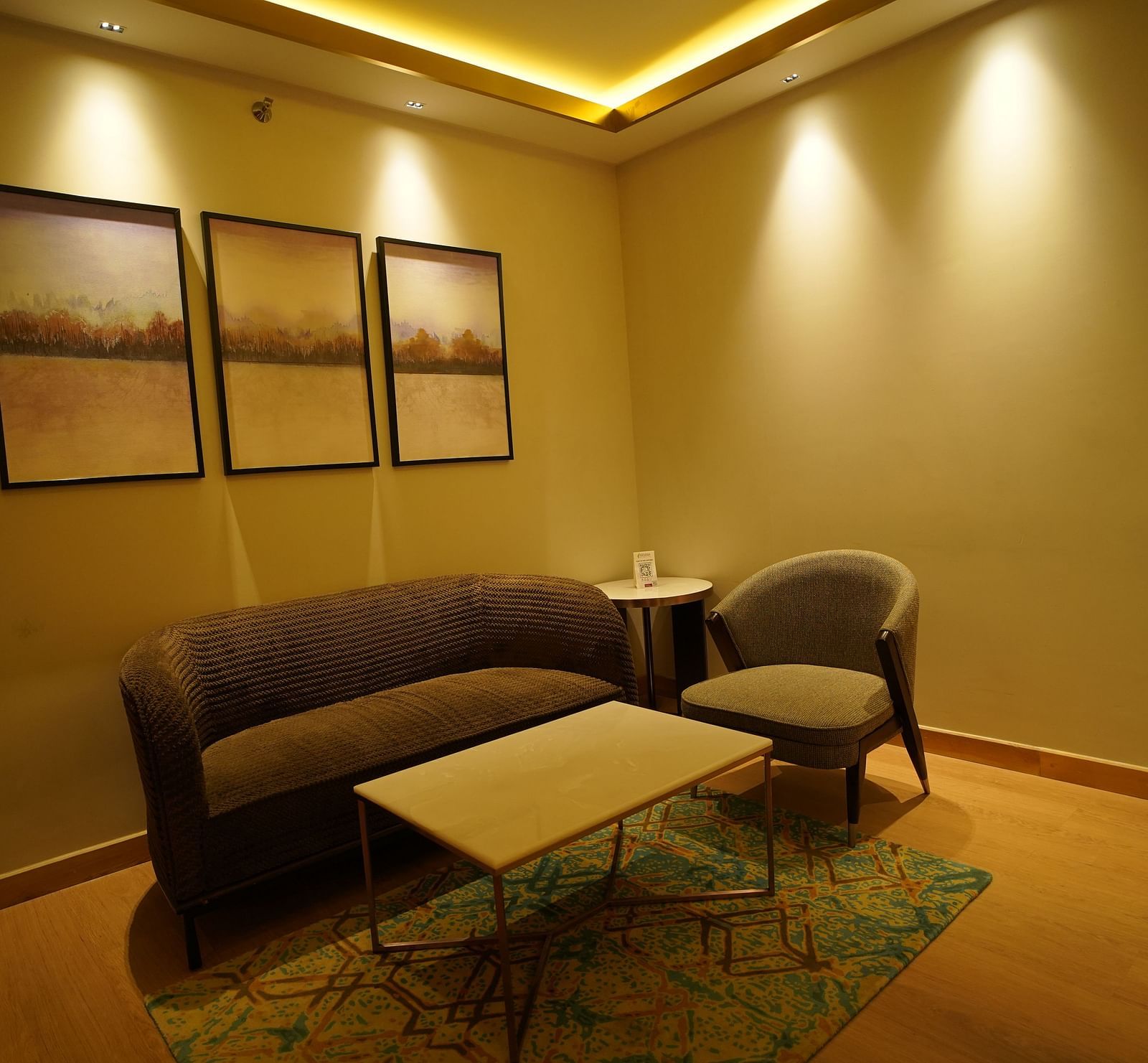 Sofa and coffee table set up with spot lighting at Nirvana Luxury Hotel, Ludhiana