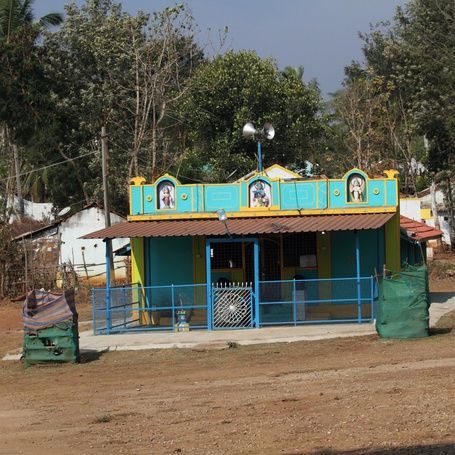 Small colorful Hindu temple in a rural setting.