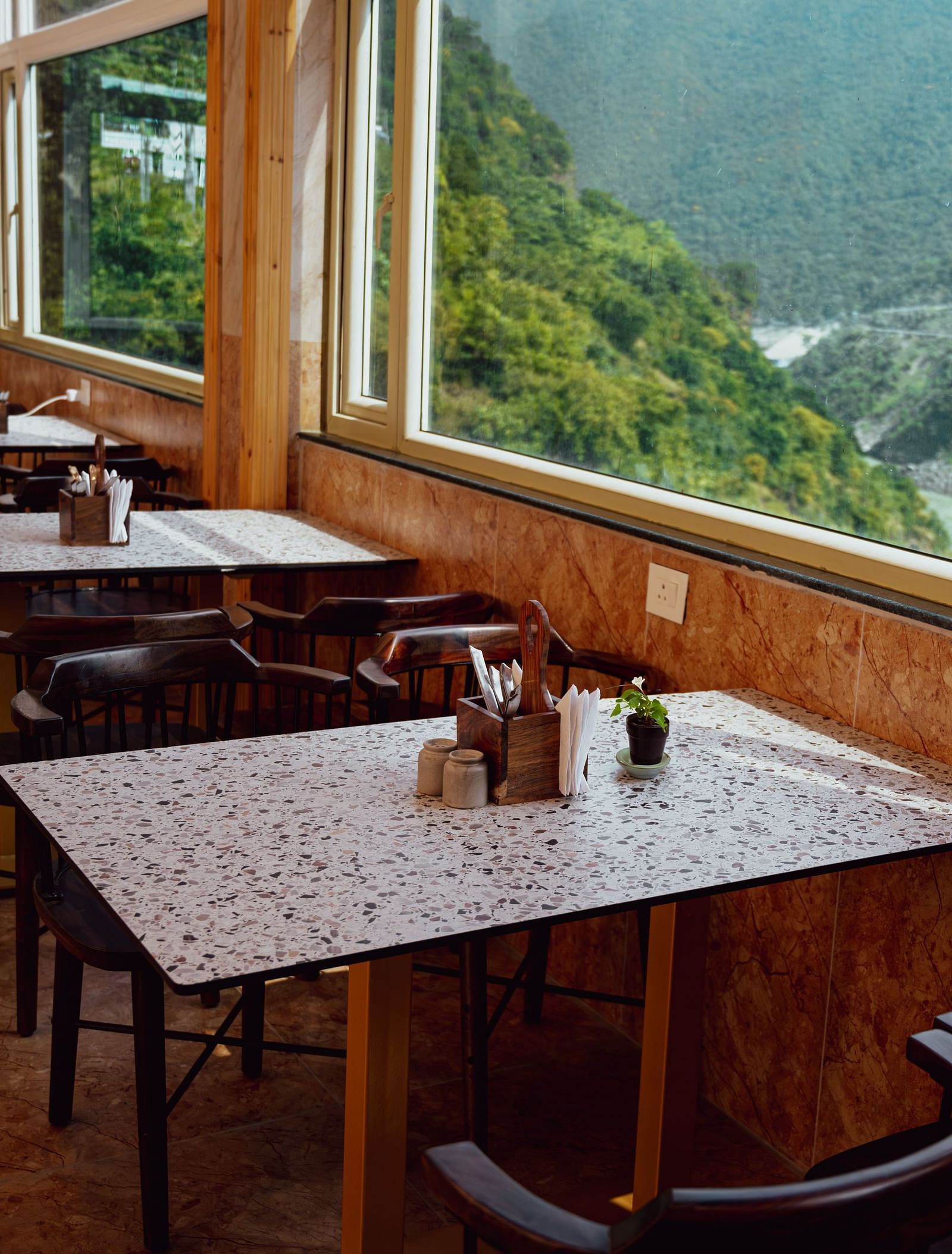 Image of the dining area by the window overlooking the mountains and the river | The Tattva Devprayag