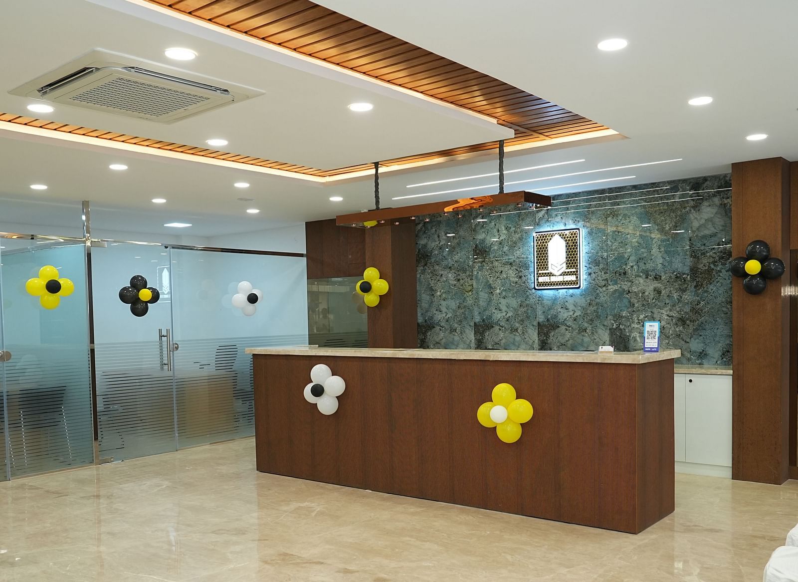 a wide angle shot of the reception area with a desk in the middle of the lobby - Hotel Grand Sigma