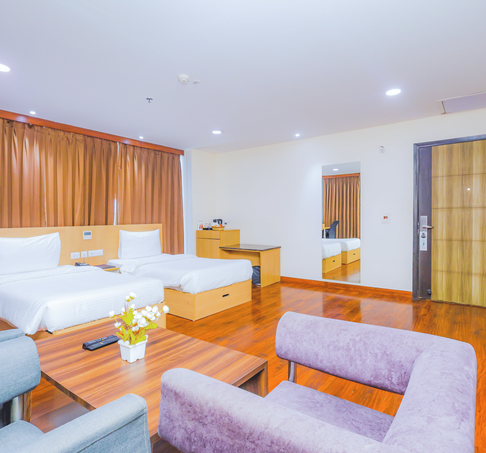 A spacious hotel suite living room with comfortable sofas and light coloured decor - Hyphen Business Hotel, Noida