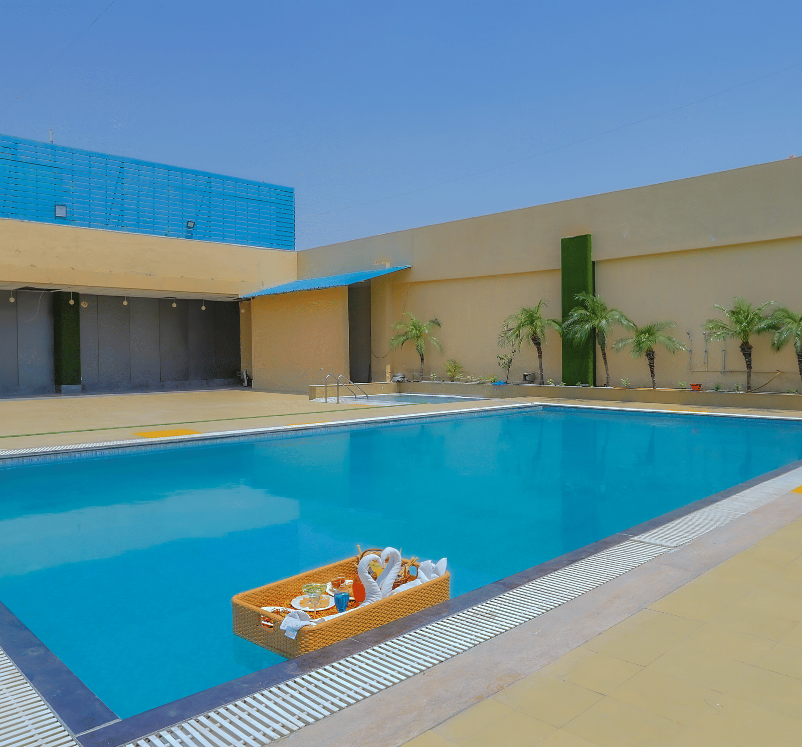 The inviting outdoor swimming pool featuring a white inflatable raft, surrounded by paved areas at The Conway, Meerut.
