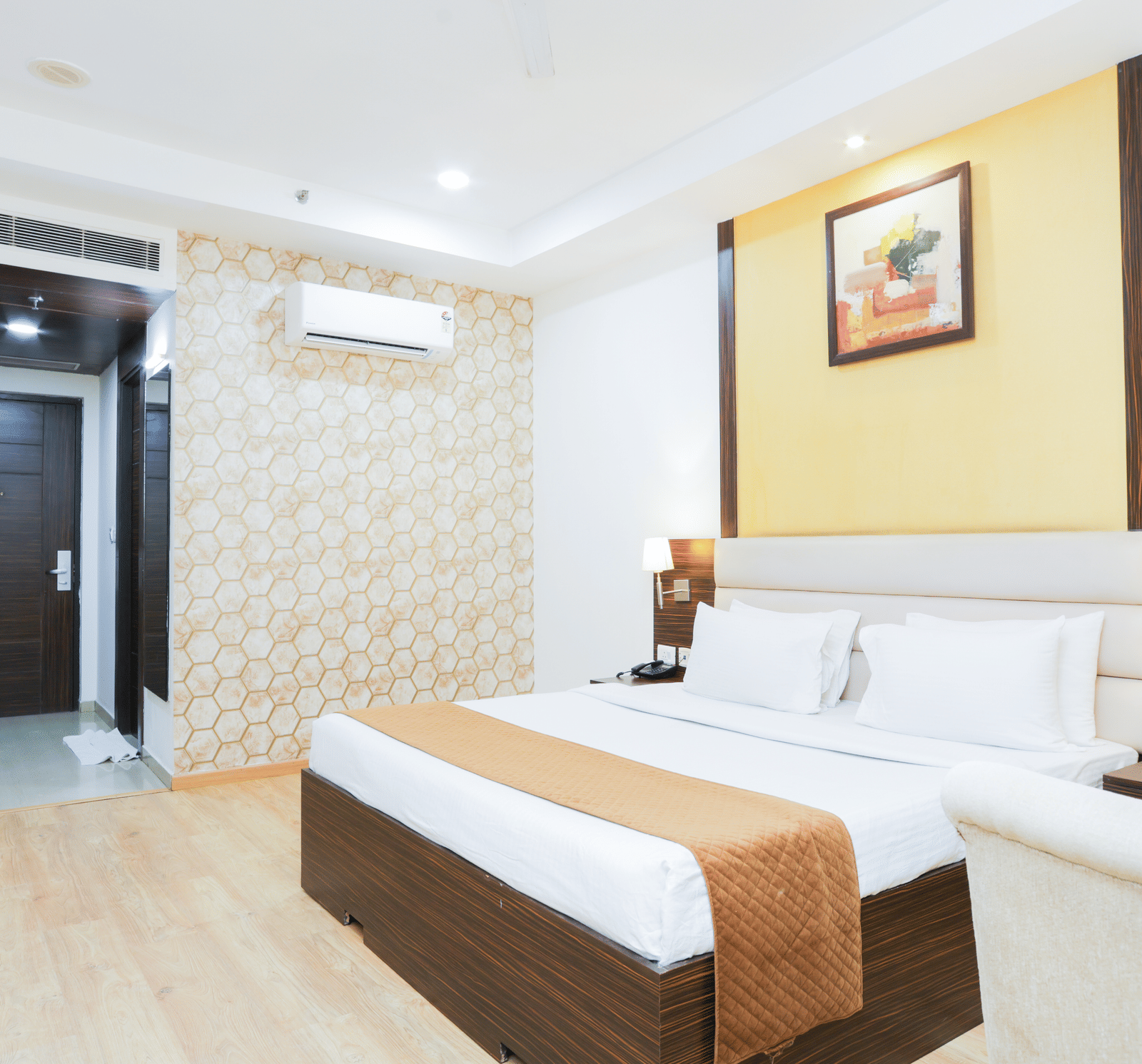 Elegant double bed room with ambient lighting, wall art, and bedside tables at Hyphen Premier Hotel, Meerut.