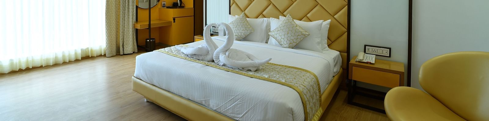 An image of a bedroom with a seating area and a phone line beside it -The President Hotel, Kumara Park, Bangalore