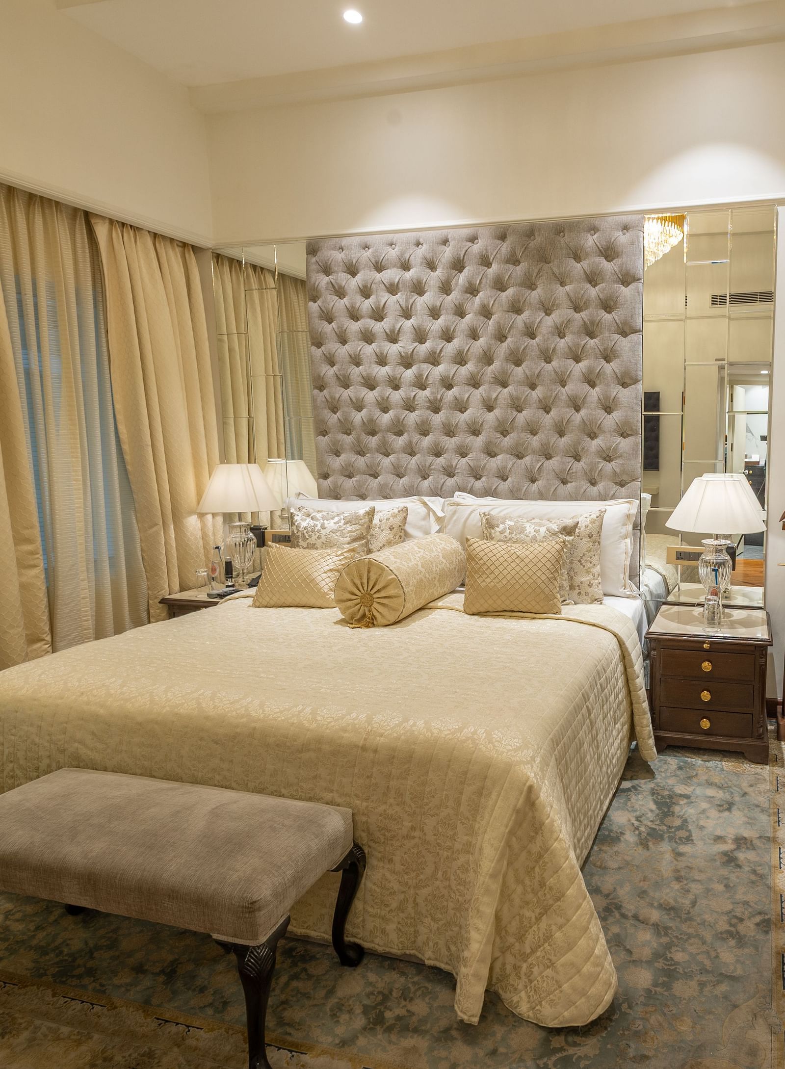 Superior Room at The Claridges New Delhi, featuring a cosy bed with bedside lights and two chairs arranged in the corner