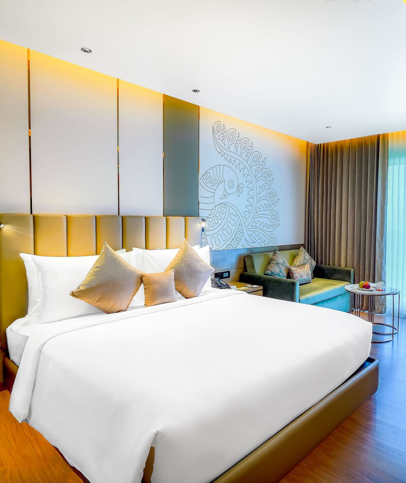 An image of our Business Class Room in Madurai with a large bed, hanging lamps. a night stand and a work desk