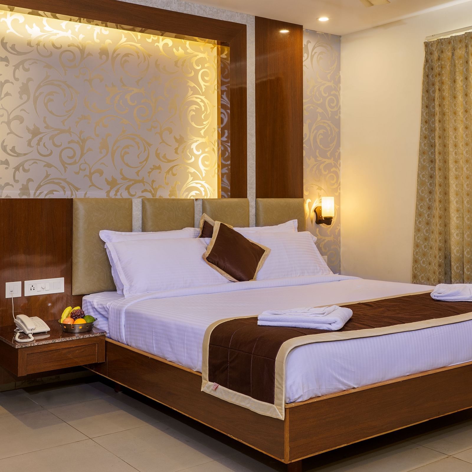 A room at Wyt Hotels, Rameswaram featuring a double size bed, bedside table, and lights installed behind the walls.