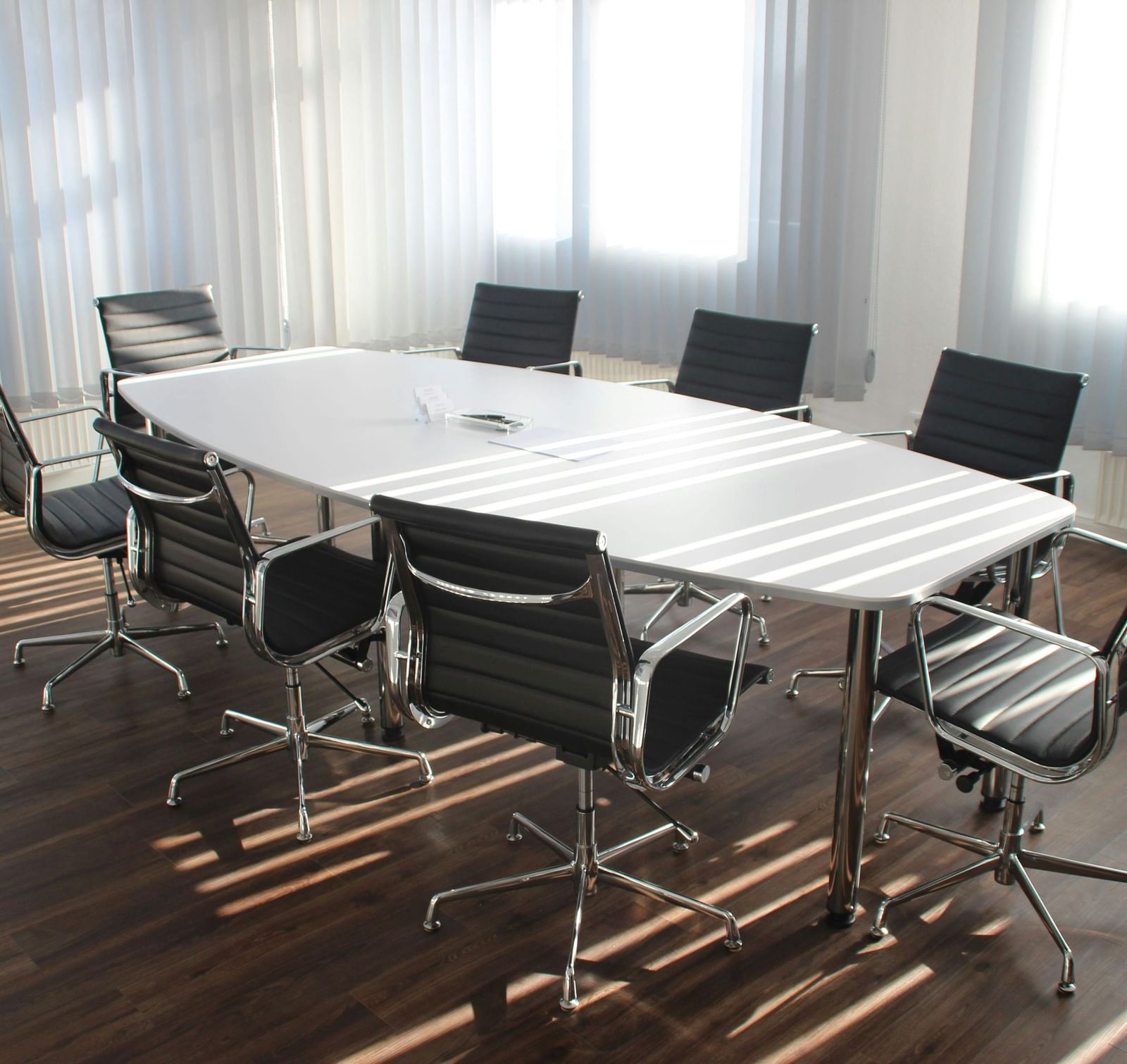 Minimalist modern meeting room featuring a sleek oval conference table and chairs