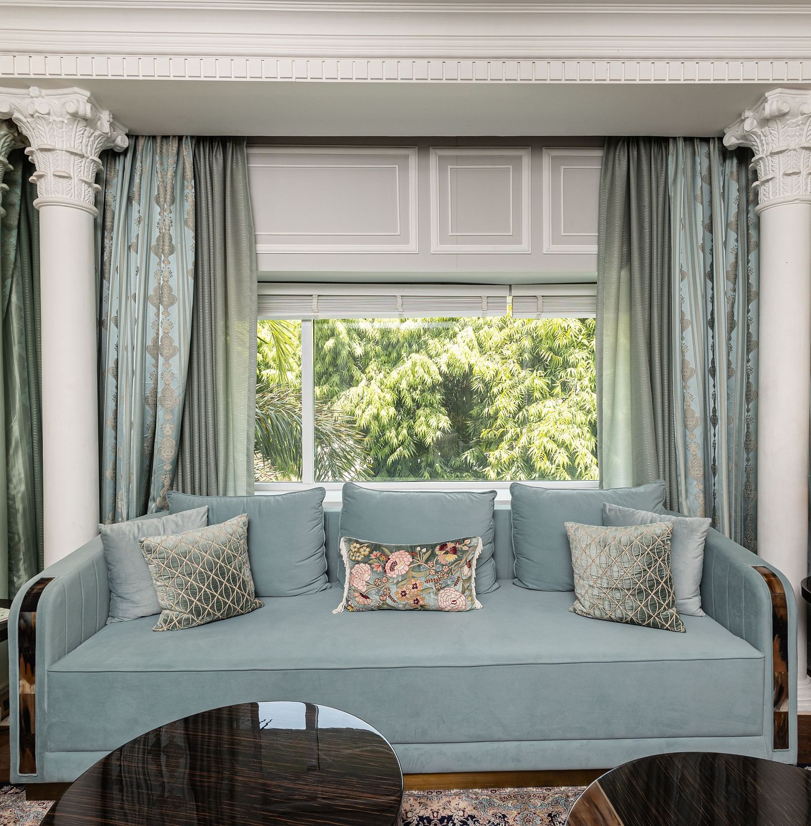 An image of a blue couch with lamps placed on either side of it at the Diplomatic suite room - The Claridges New Delhi