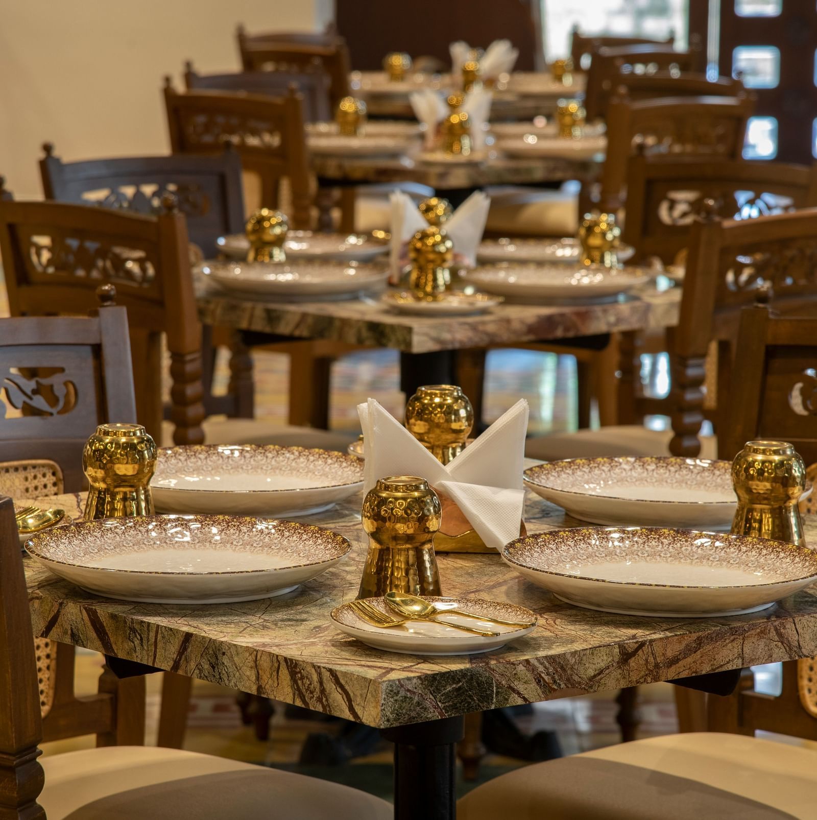  An image of dining area featuring chairs, plates on the table, and salt and pepper shakers - The President Hotel, Kumara Park, Bangalore