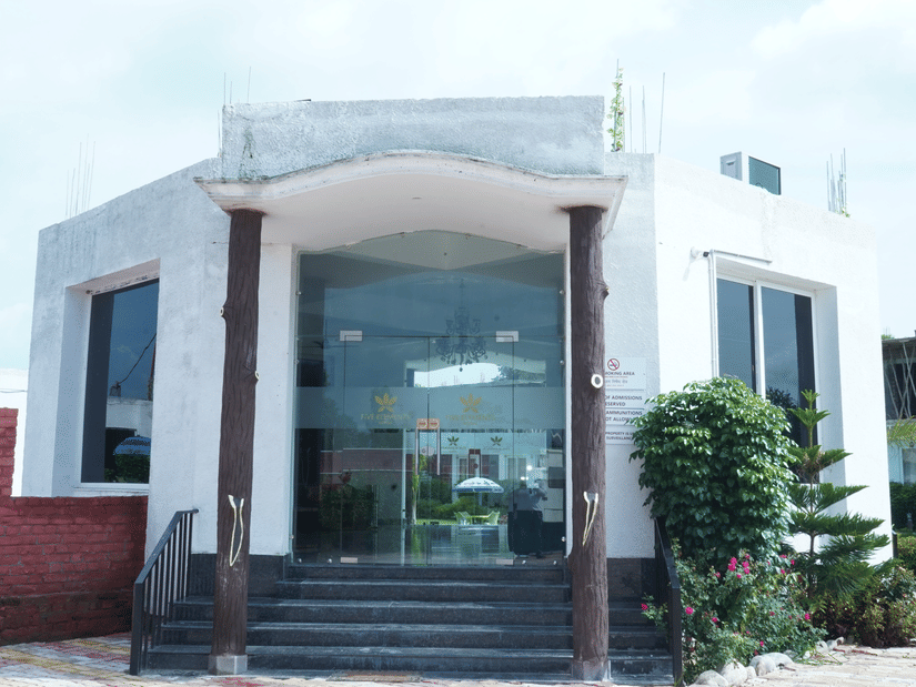 Exterior front entrance view of the hotel main building featuring large glass doors, steps, and surrounding landscape - Five Elements Hotels, Corbett Crown Resort, Jim Corbett
