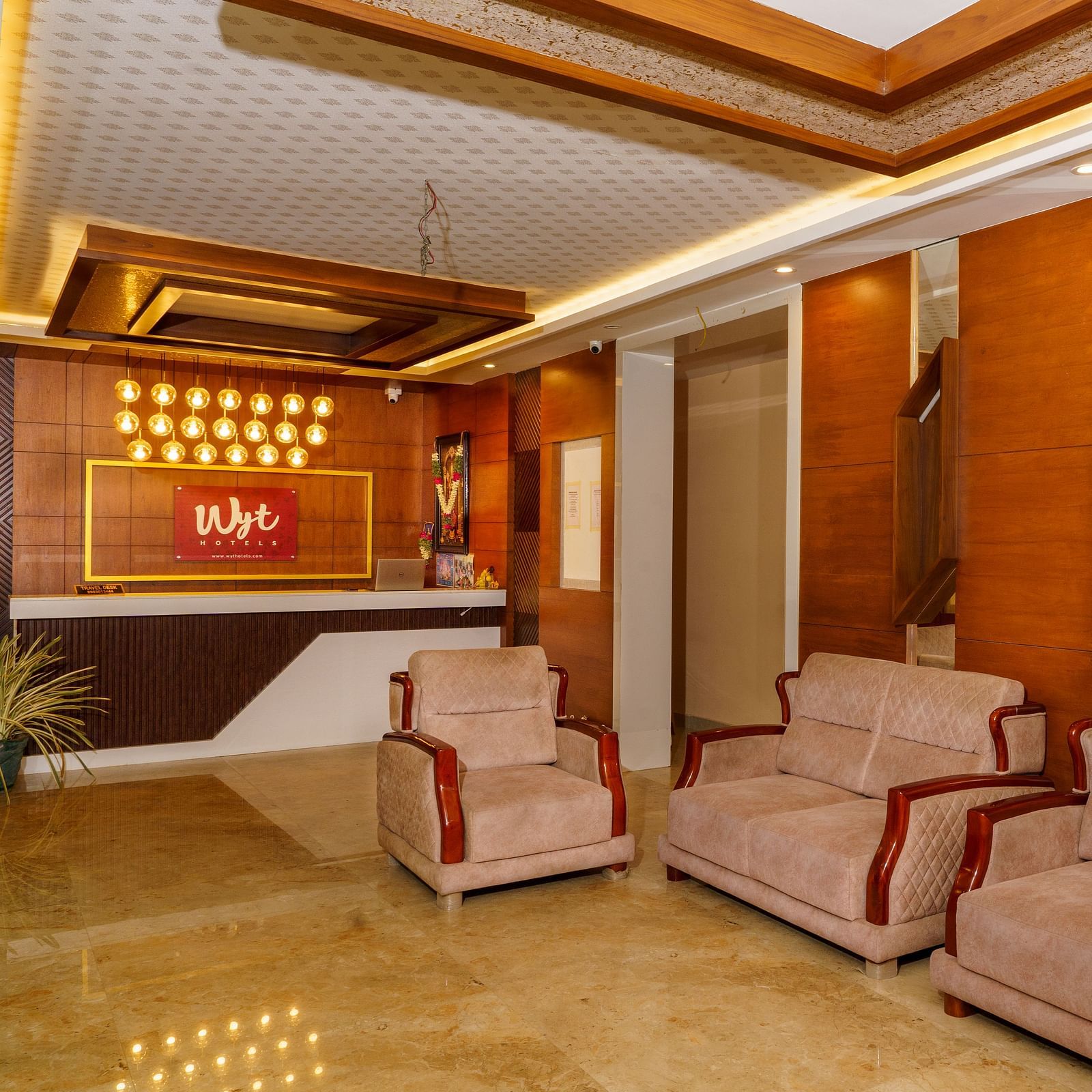 Lobby area with sofas and wooden wall panel at Wyt Hotels, Rameswaram