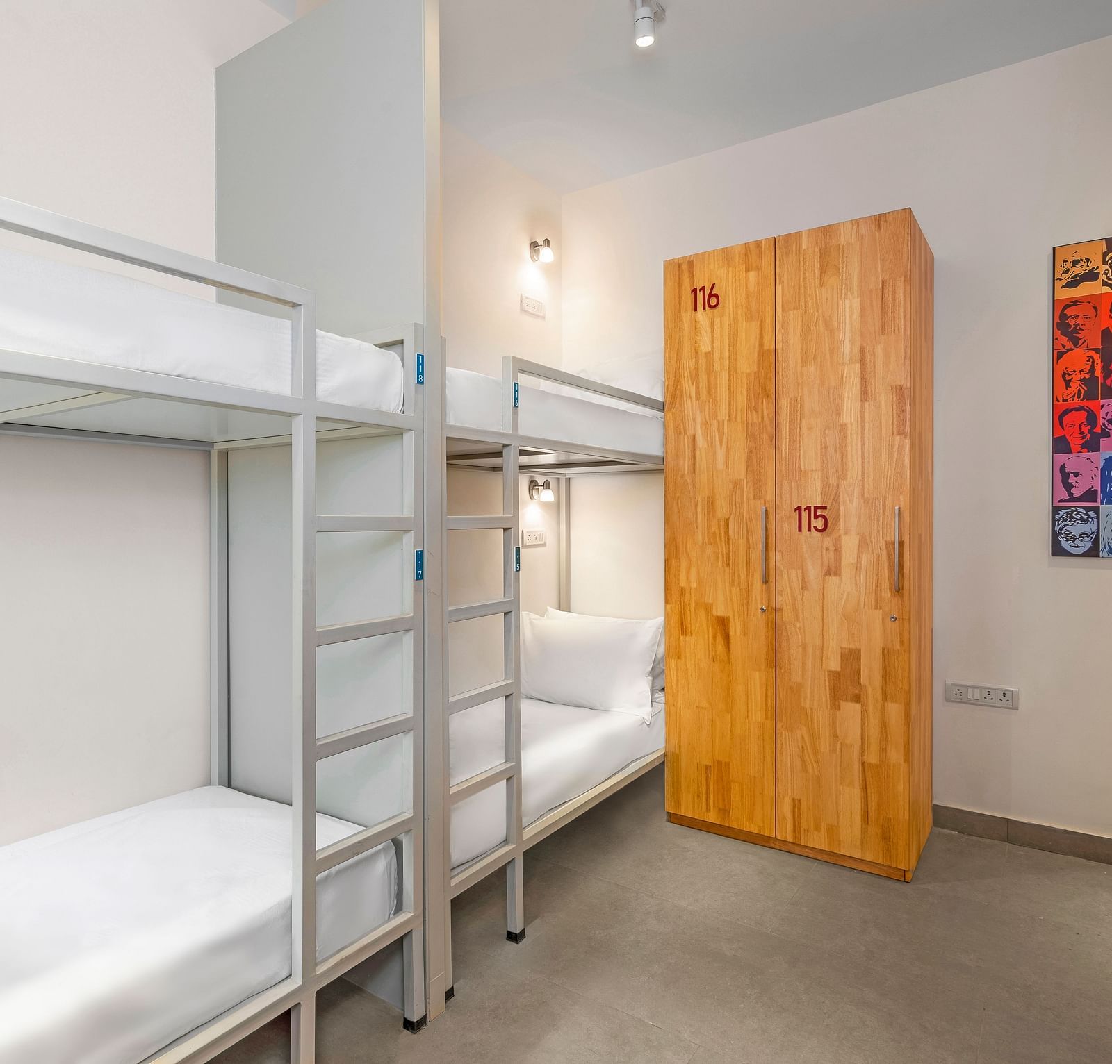 A side angle view of a dorm at Bedzzz in Varanasi features a spacious layout with a cupboard, highlighting the practical design that combines comfort and storage for guests. The inviting ambiance creates a cozy environment for relaxation and rest.