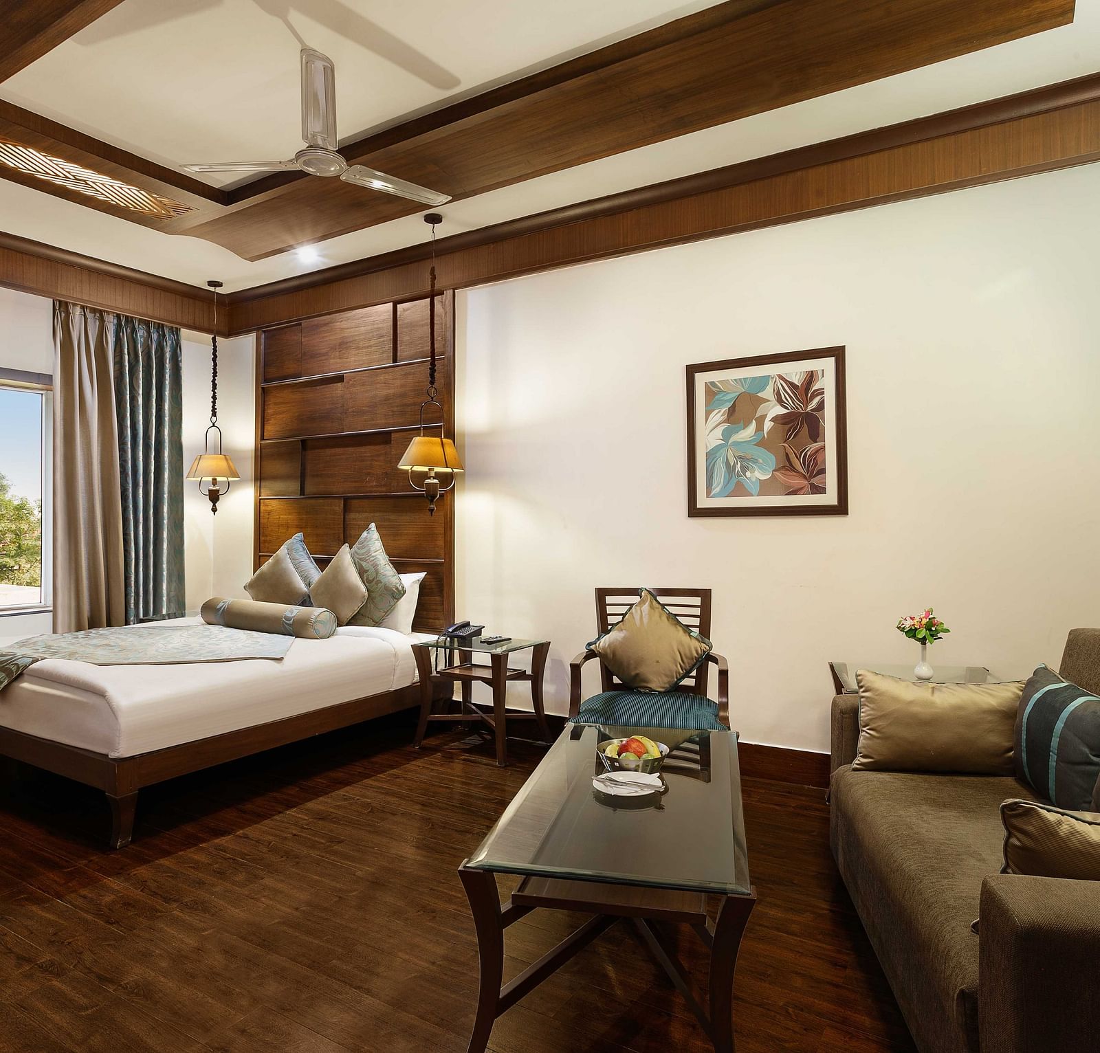 a view of a bedroom with a large bed in the corner and a sofa with a table - The Manor, Kashipur
