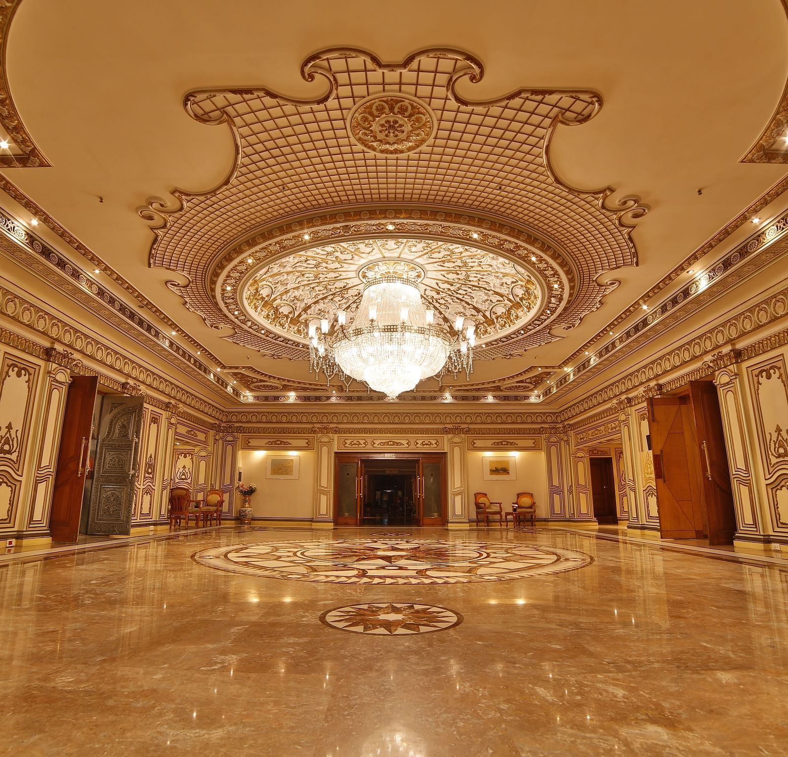  Interiors of Rang Mahal hall A grand hotel suite with an opulent red and white decor, large bed, and seating area, reflecting a traditional style at Sitara Luxury Hotel in Hyderabad near Ramoji Film City.