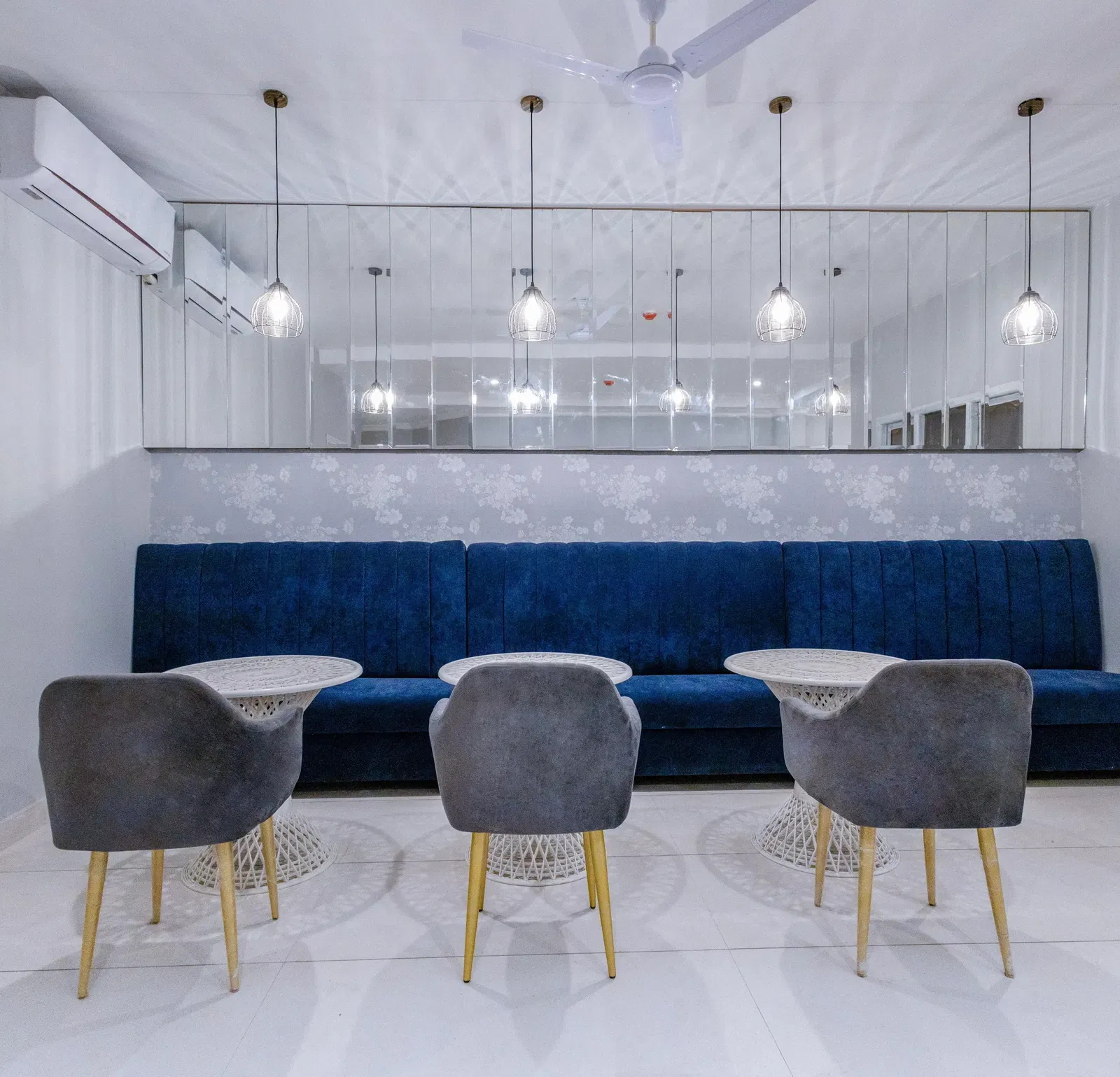 Restaurant area featuring modern chairs and tables against a dark blue wall. - Hotel Downtown17, Chandigarh 