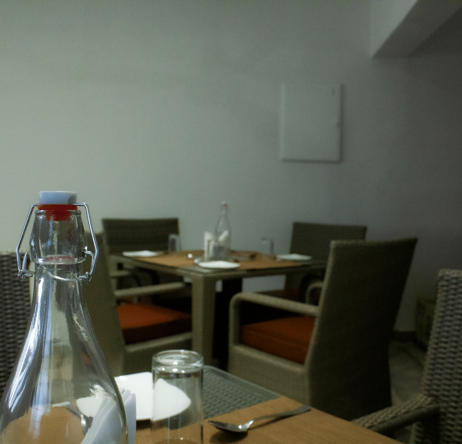Side view of the Spice and Slice Restaurant at WOW Naturefull Resorts, Yercaud, overlooking other dining dining tables lined with table mats and plates.