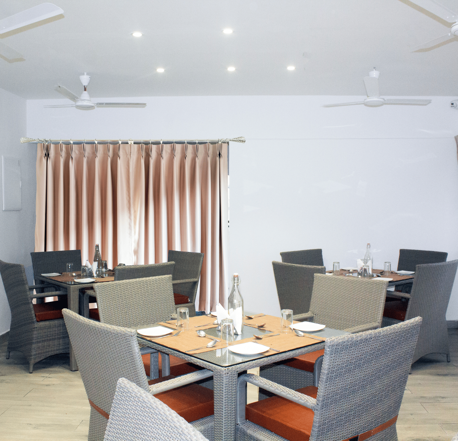 A wide-angle shot of the Spice and Slice Restaurant with 3 dining tables arranged in the dining area at WOW Naturefull Resorts, Yercaud.