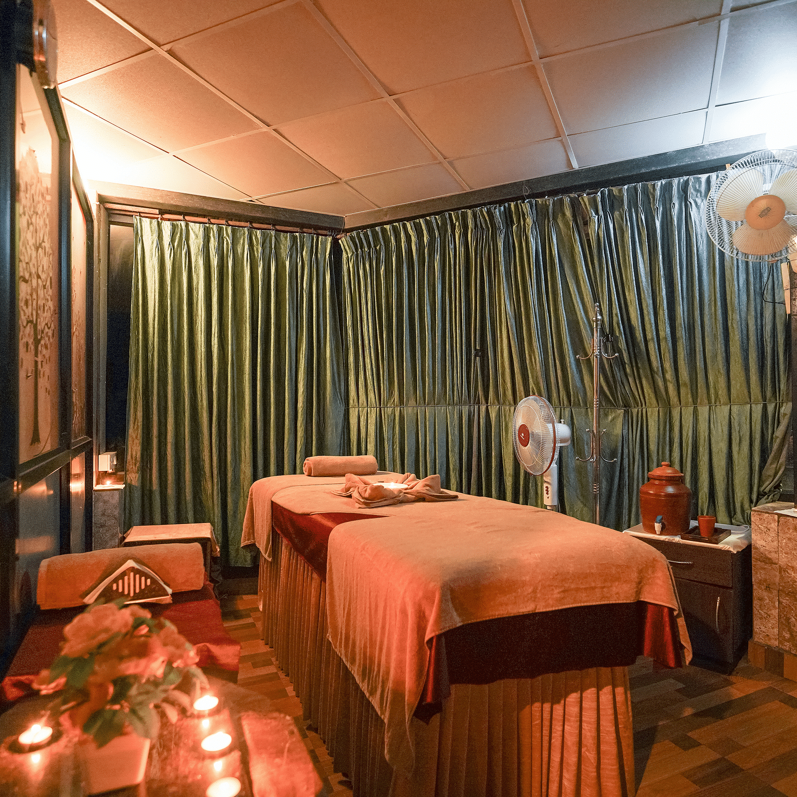 A spa with a bed and candles at Coorg Jungle Camp Backwater Resort, Kushalnagar.