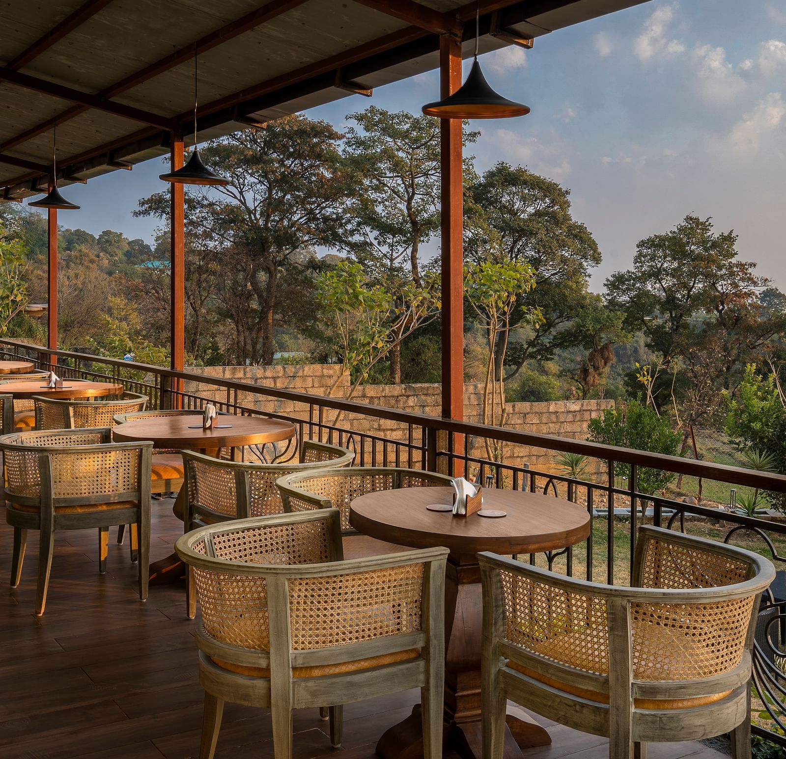 An image of Outdoor seating area with a view of trees and mountains at Atman, dharamshala.