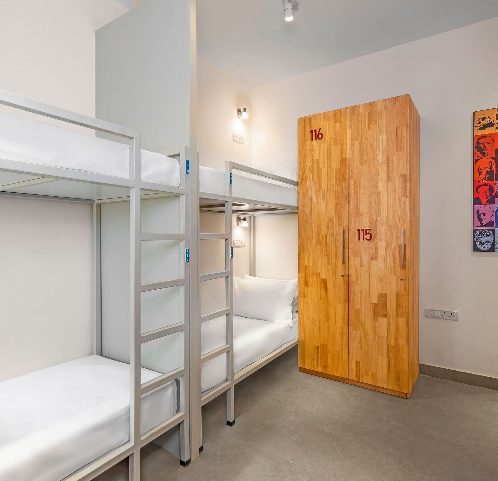 A side angle view of a dorm at Bedzzz in Varanasi features a spacious layout with a cupboard, highlighting the practical design that combines comfort and storage for guests. The inviting ambiance creates a cozy environment for relaxation and rest.