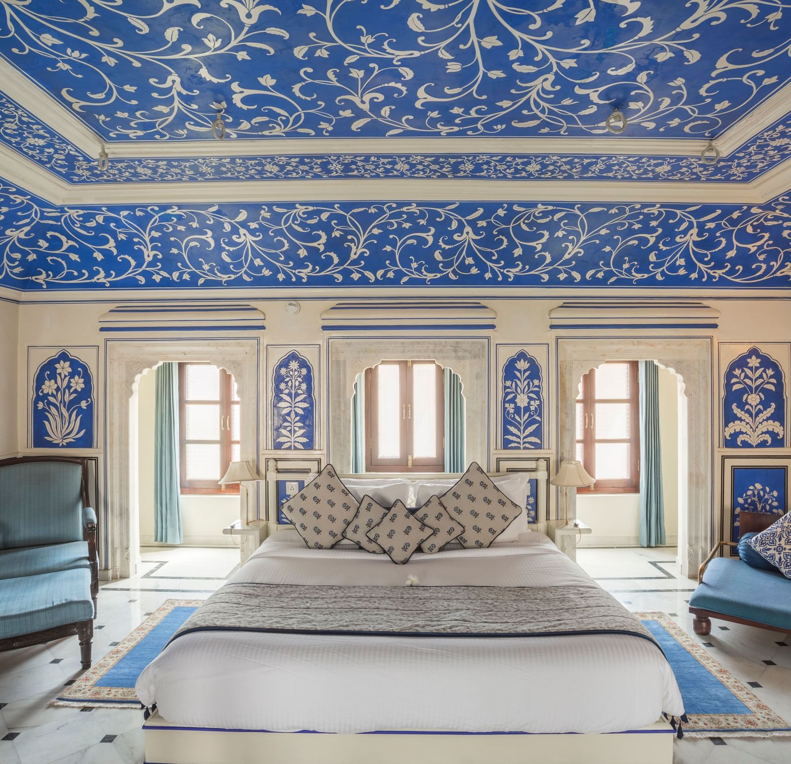 A bedroom at Royal Heritage Haveli featuring a large bed and walls and ceiling adorned with intricate blue and white patterns.
