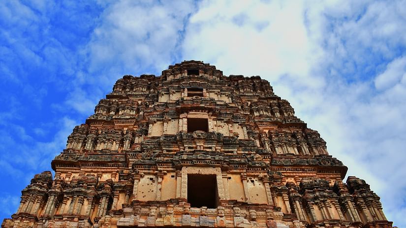 A stunning low-angle shot of a temple with intricate architecture set against the backdrop of a cloudy sky - Hotel near Tirupati temple