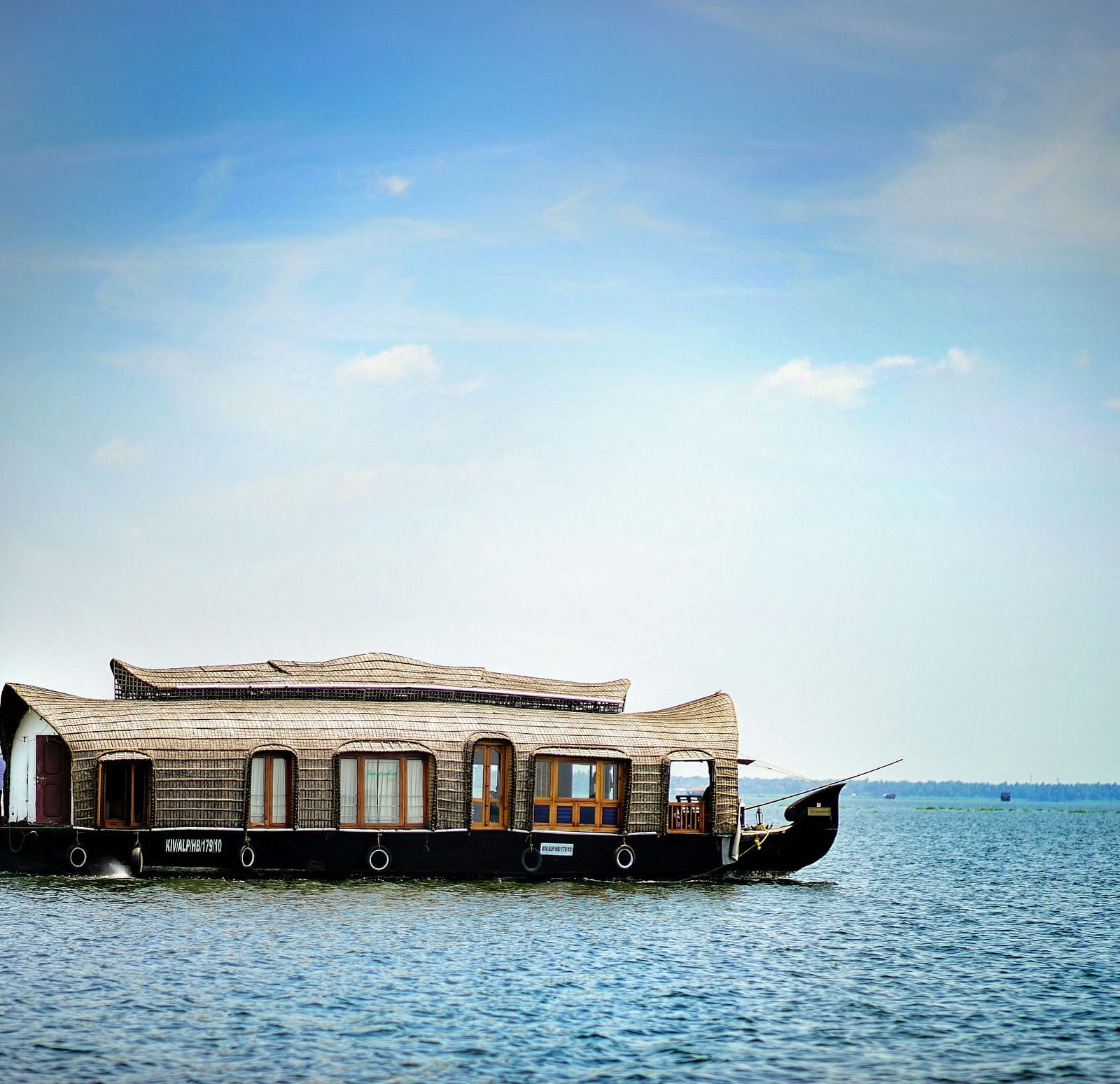 An overview of a houseboat in the water with blue sky in the background