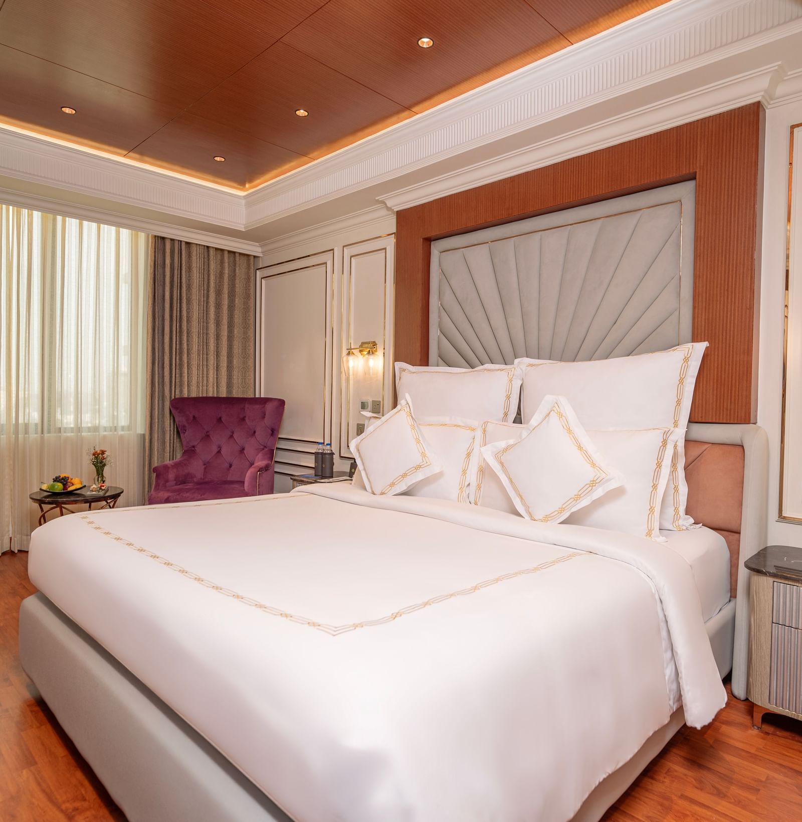 King size bed in a room at Accord Metropolitan with two side tables and wall panelling.