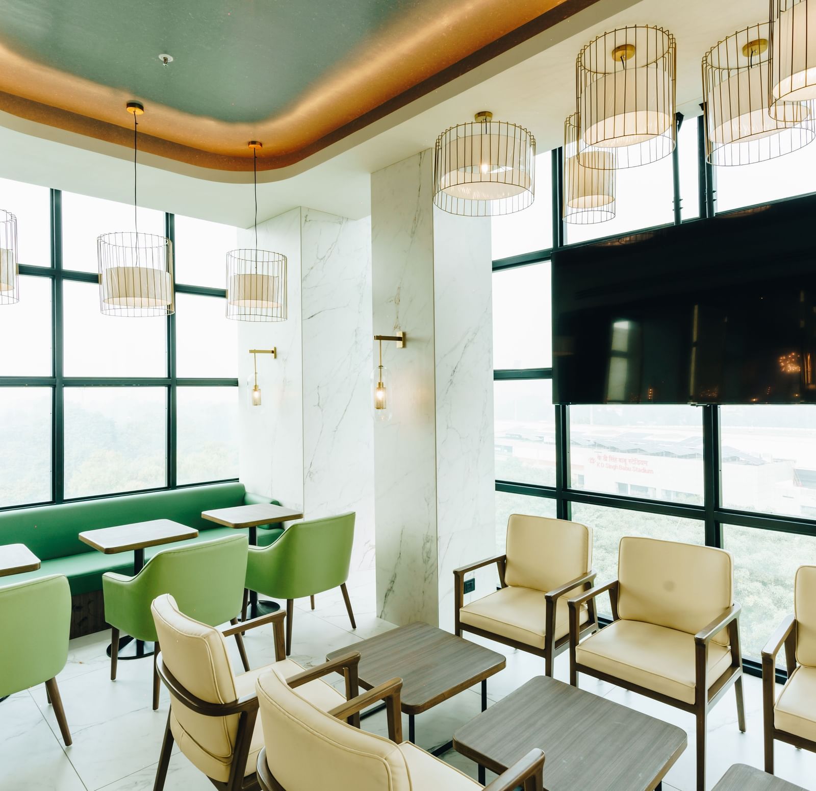 A bright and stylish lounge area with modern seating and large windows, reflecting the welcoming ambience of Gemini Continetal, a hotel near Lucknow City Railway Station.
