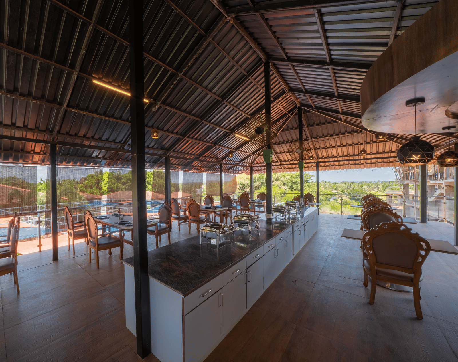 Our restaurant offering 4-person seating areas, a central buffet counter, and a view of Morjim Beach - Perfectstayz Koko Maya