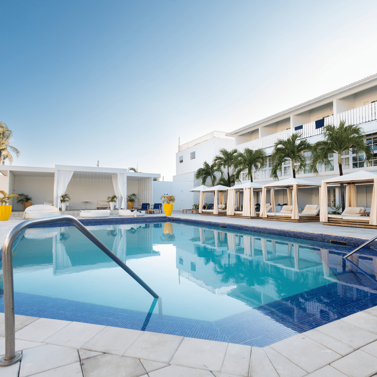 A side angle view of the pool with The Soco House's facade and the lounge space at the backdrop.