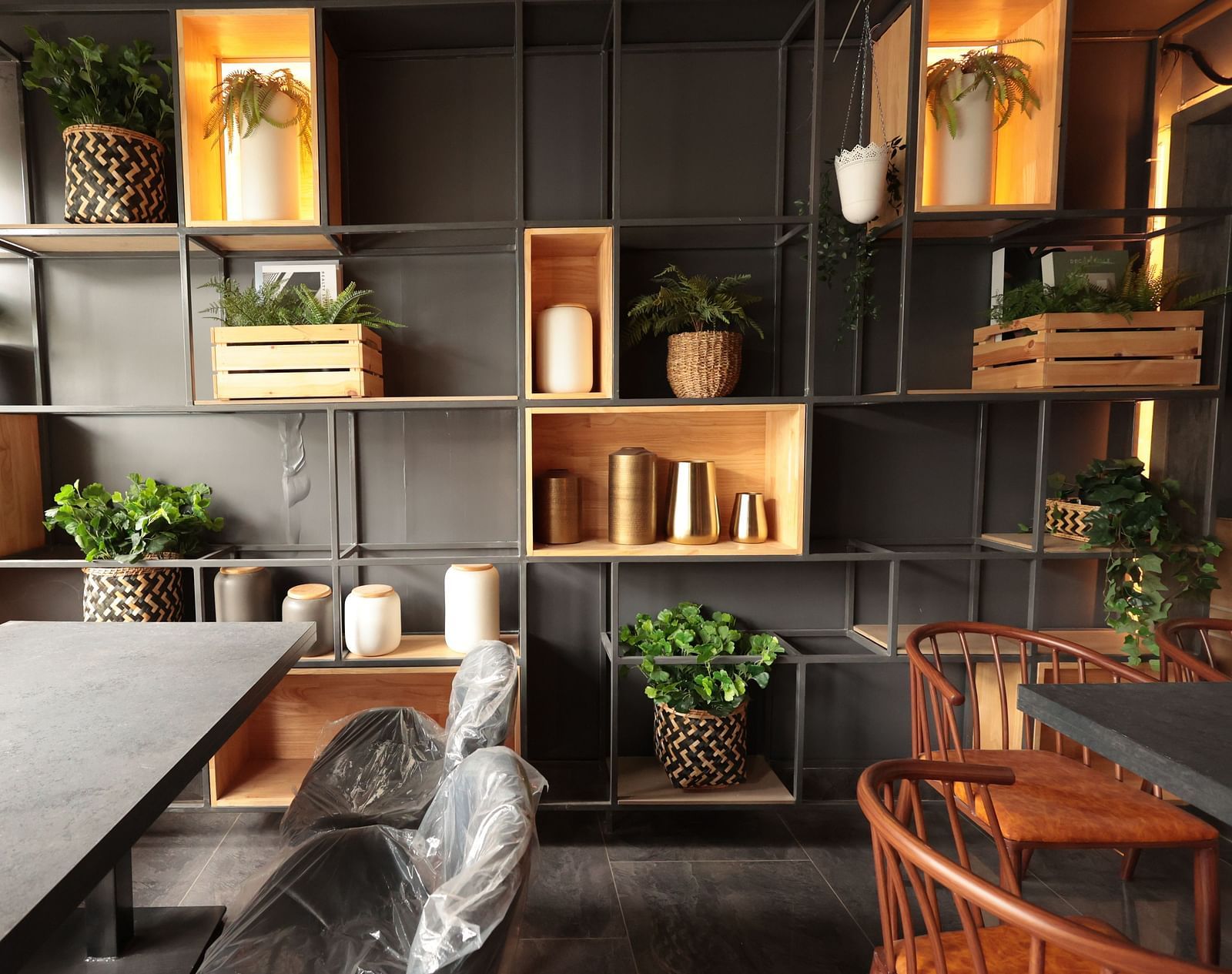 A spacious dining area with a background shelf decorated with plants, pots, and vessels | Cenneys Gateway