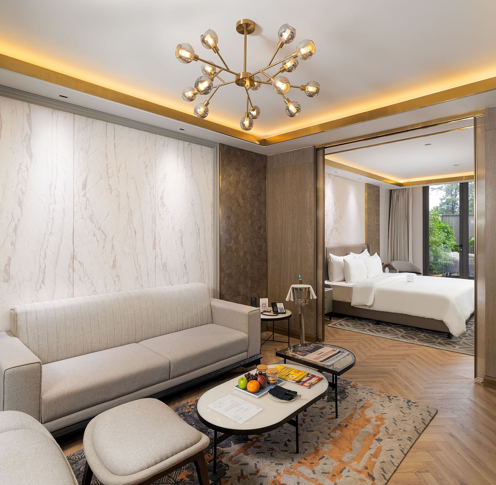 Elegant Nirvana Suite living area with a stylish sofa, a chic coffee table, and an open view into the spacious bedroom - Nirvana Luxury Hotel, Ludhiana