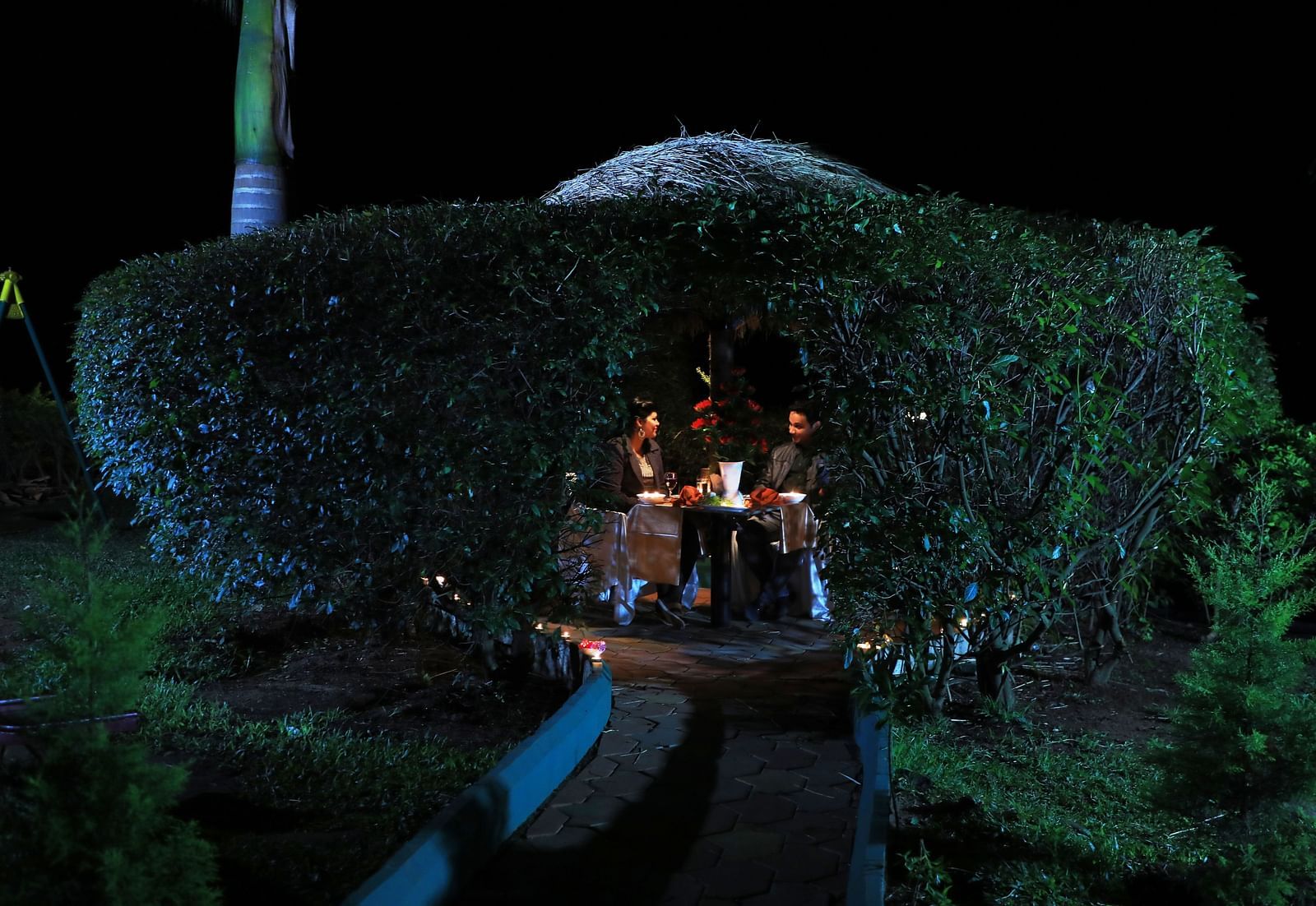 Image of two people dining at an outdoor setting at Coorg Jungle Camp Backwater Resort, Kushalnagar.