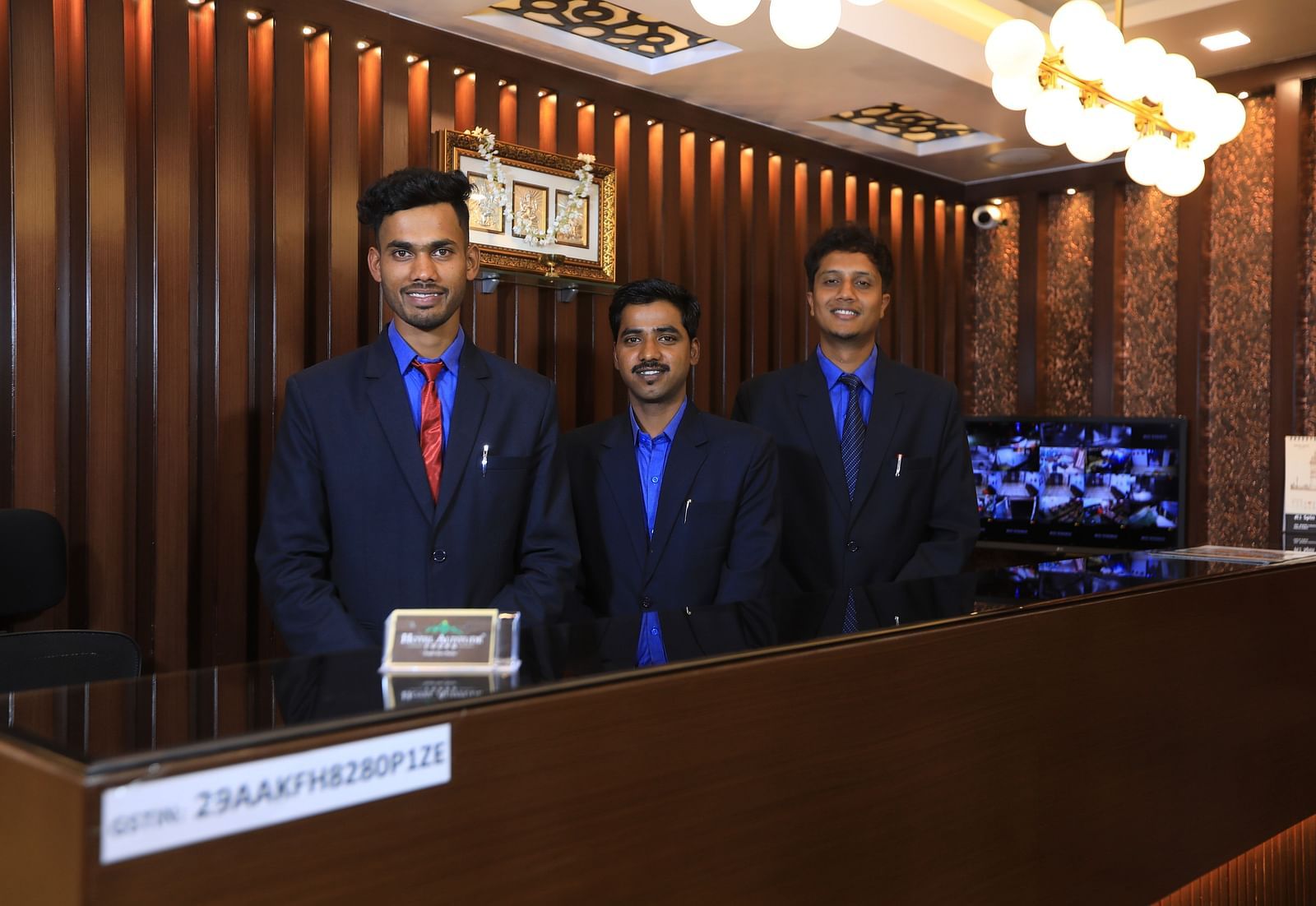 Image of three people standing behind a table and posing for the lens at Hotel Altitude, Madikeri.