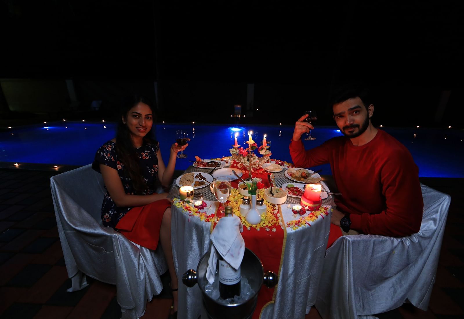 Image of two people sitting on chairs with a table filled with food in front of them at Parampara Resort & Spa, Kushalnagar.