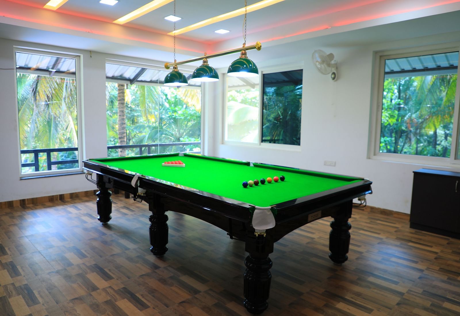 Image of a pool table with lights above it at Parampara Resort & Spa, Kushalnagar.