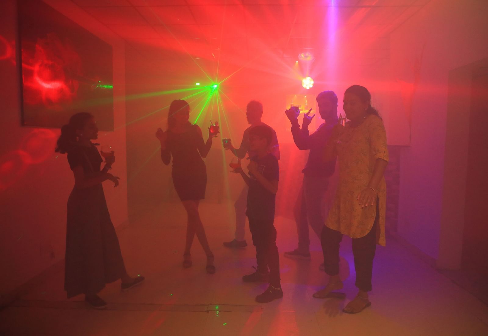 Image of a group of people dancing with colourful lights lighting the room at Parampara Resort & Spa, Kushalnagar.