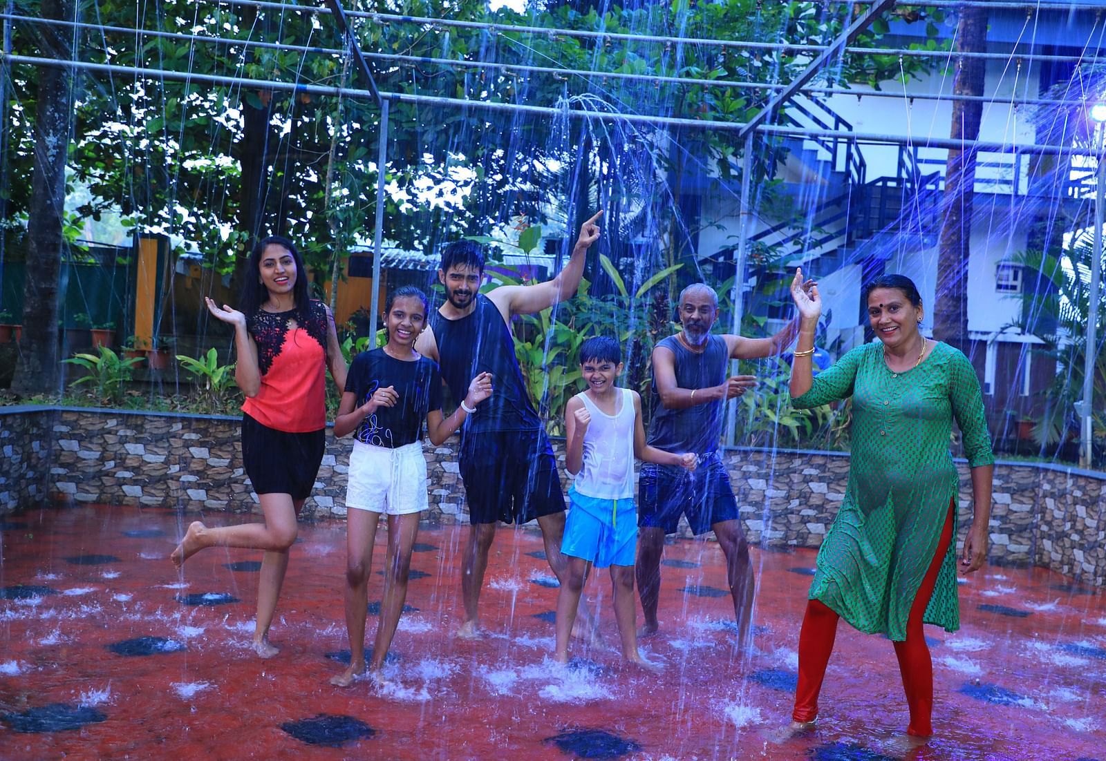 Image of a group of people taking part in a rain dance at Parampara Resort & Spa, Kushalnagar.