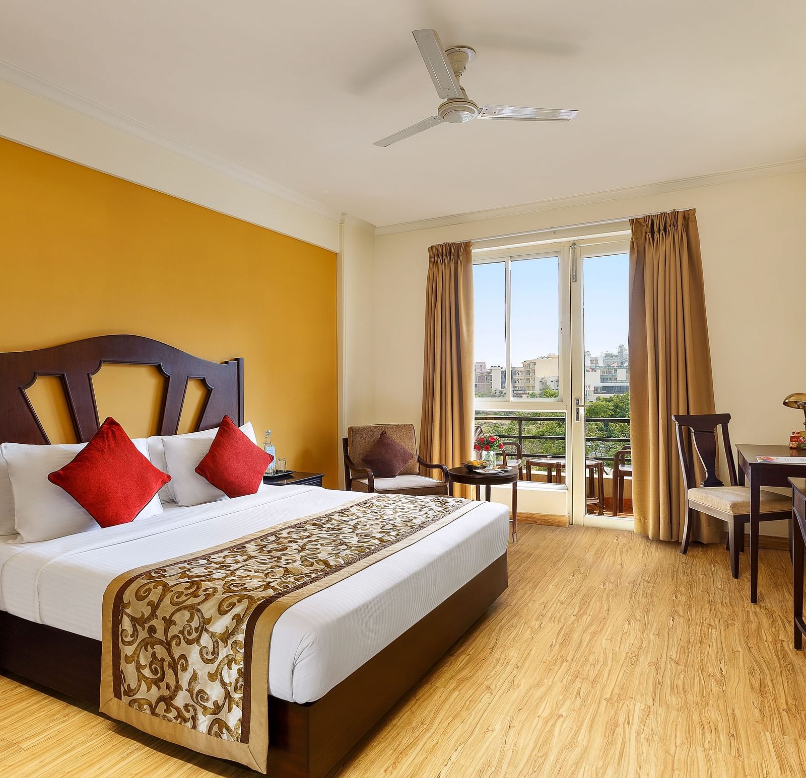 One bedrooom standard apartment with a large bed facing a television and a workdesk and ceiling fan - Aloha On The Ganges, Rishikesh