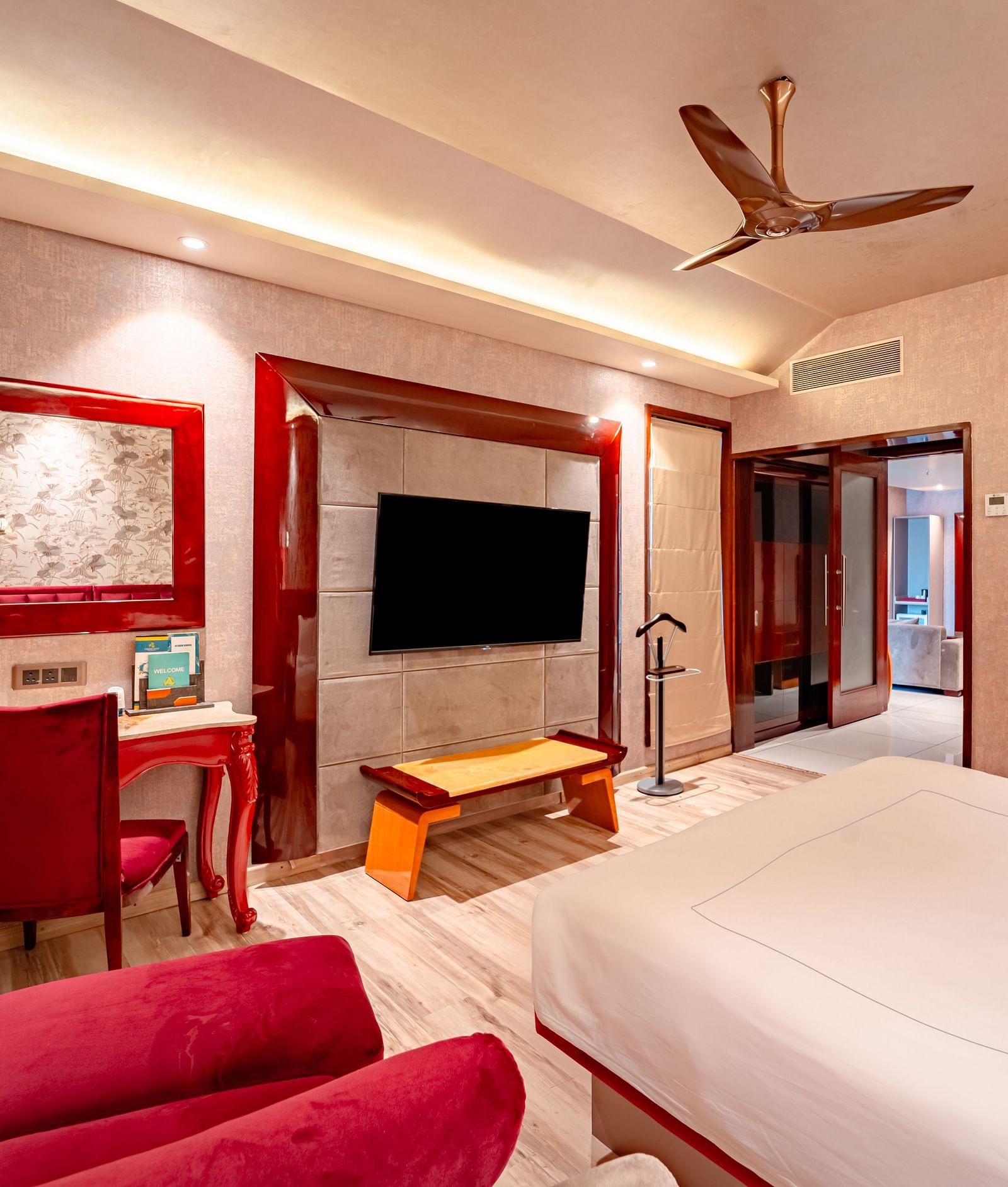 Executive Suite features a spacious bed with a bedside table, warm lighting, and a pathway leading to the next room at Crescent Spa & Resort, Indore
