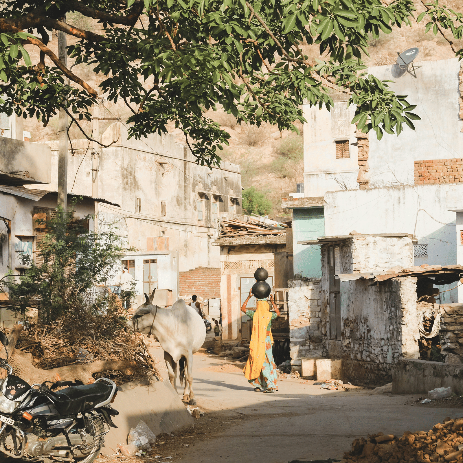image of a village with a woman carrying a pot on her head
