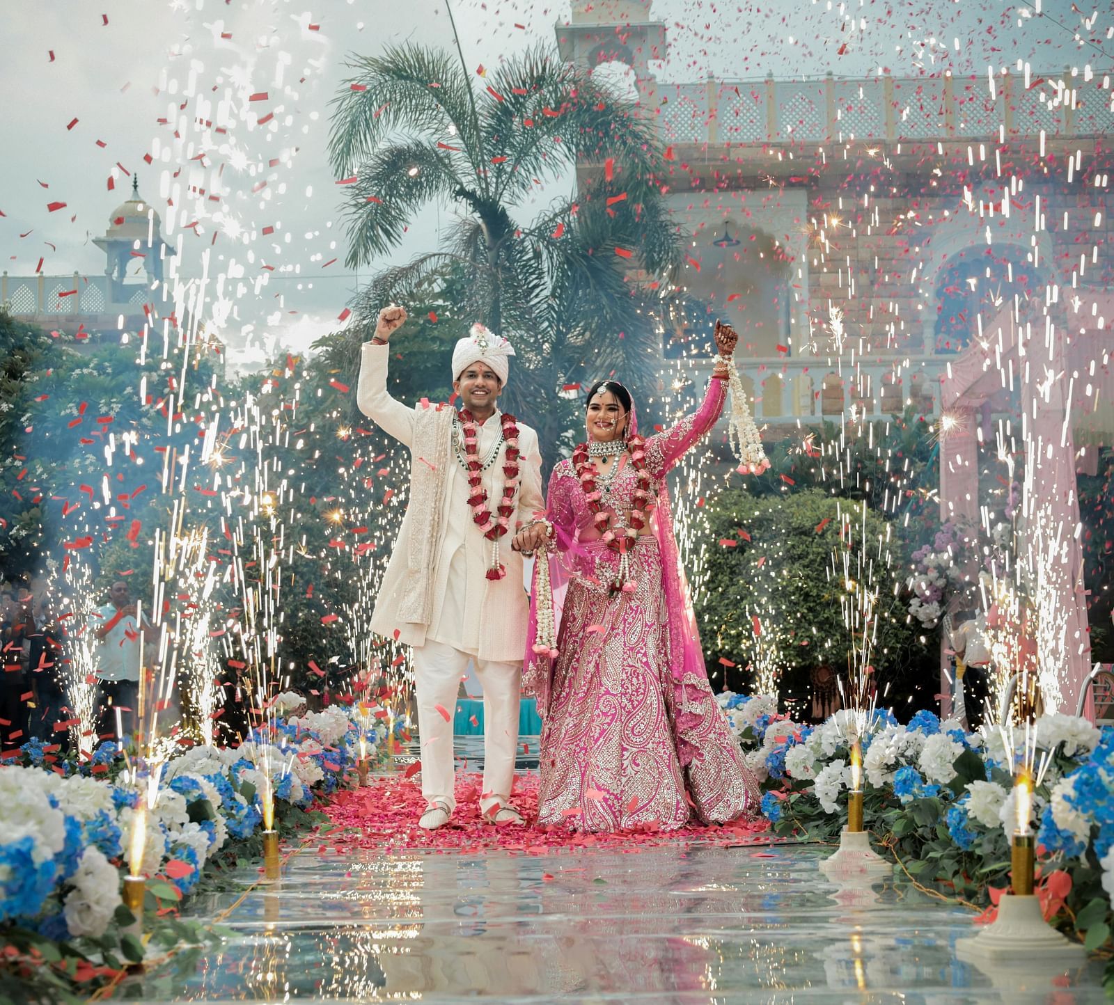 An image of a bride and groom walking on the isle hand in hand with confetti and crackers bursting behind them to celebrate the successful wedding